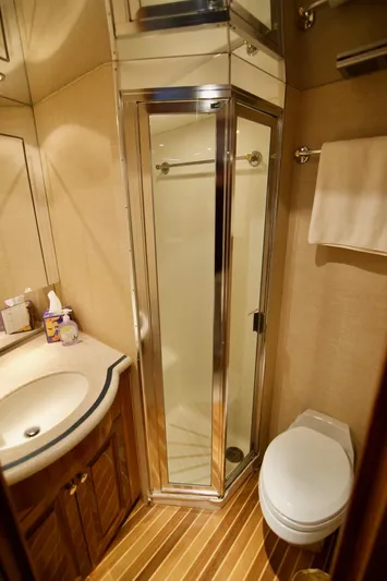 Grape Escape Yacht Photos Pics Bathroom interior of 2000 Hatteras 60 Convertible yacht with shower, sink, and toilet.