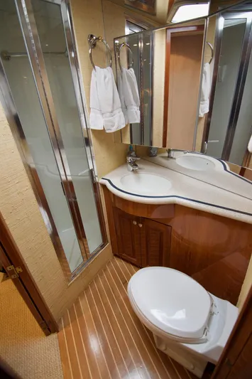 Grape Escape Yacht Photos Pics Luxurious bathroom in 2000 Hatteras 60 Convertible yacht with modern fixtures and wood accents.