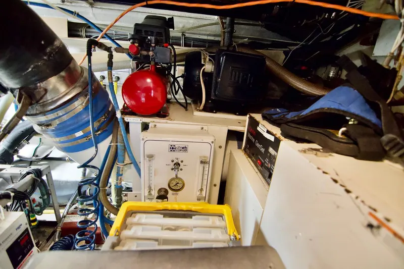 Grape Escape Yacht Photos Pics Engine room of 2000 Hatteras 60 Convertible yacht, featuring mechanical equipment and storage.