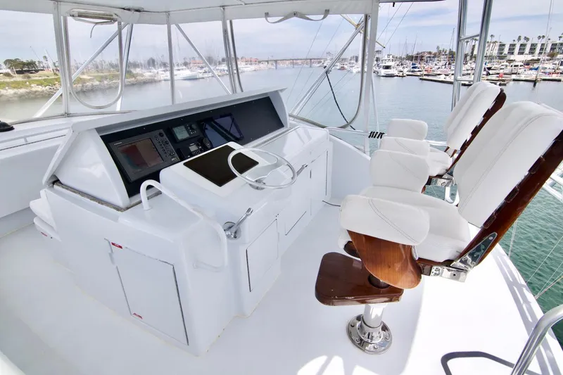 Grape Escape Yacht Photos Pics Helm of 2000 Hatteras 60 Convertible yacht with white seating and navigation equipment.