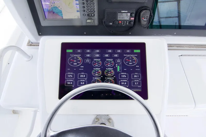 Grape Escape Yacht Photos Pics Control panel of a 2000 Hatteras 60 Convertible yacht with digital displays and navigation equipment.