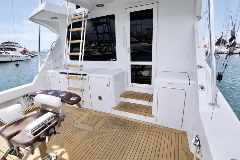 Grape Escape Yacht Photos Pics Hatteras 60 Convertible 2000 yacht deck with fishing chair and ladder in marina.