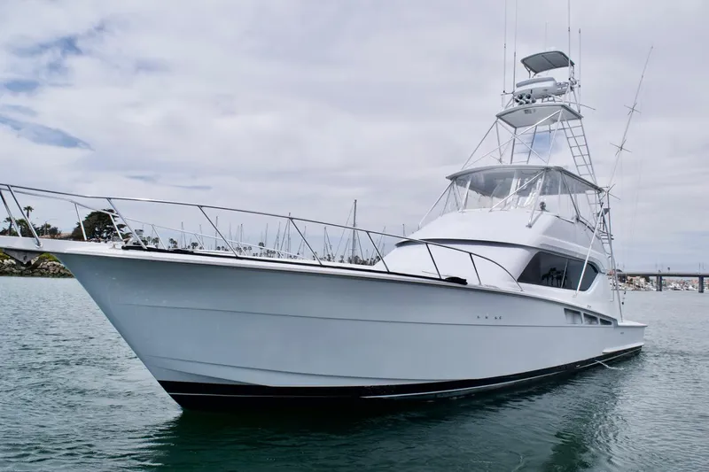 Grape Escape Yacht Photos Pics 2000 Hatteras 60 Convertible yacht on calm water under cloudy sky.