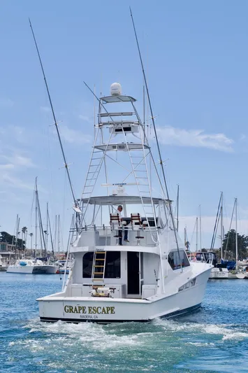 Grape Escape Yacht Photos Pics 2000 Hatteras 60 Convertible yacht, "Grape Escape," cruising in a marina.