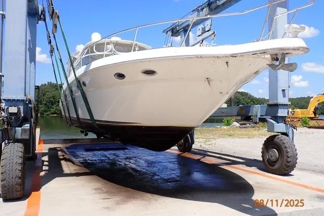  Yacht Photos Pics 2003 Sea Ray Sundancer 460 yacht being lifted by a boat hoist on a sunny day.