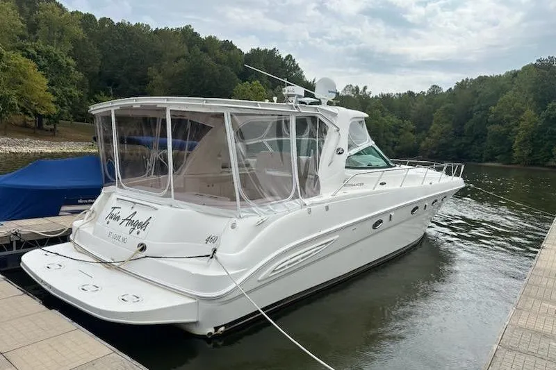  Yacht Photos Pics 2003 Sea Ray Sundancer 460 yacht docked on a serene lake with lush greenery.