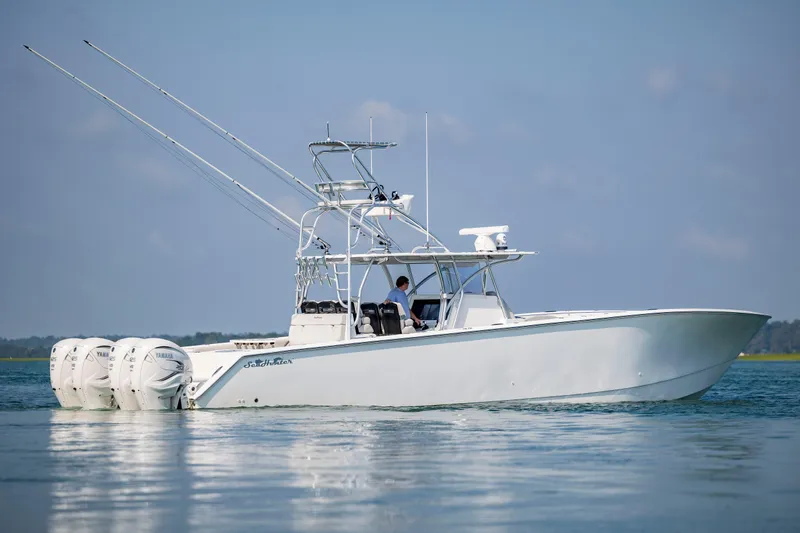  Yacht Photos Pics 2023 SeaHunter 46 CTS boat on calm water, featuring triple outboard engines.