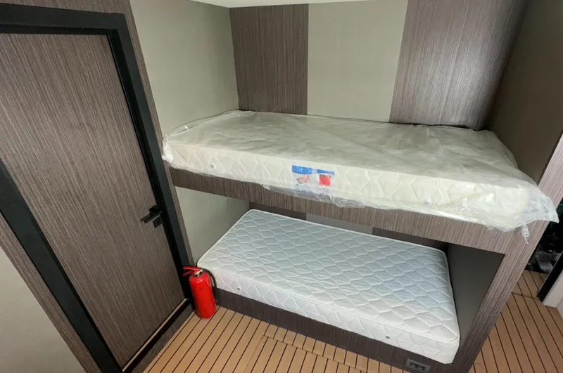  Yacht Photos Pics Bunk beds in 2023 Carboyacht 90 cabin with wooden flooring and fire extinguisher.