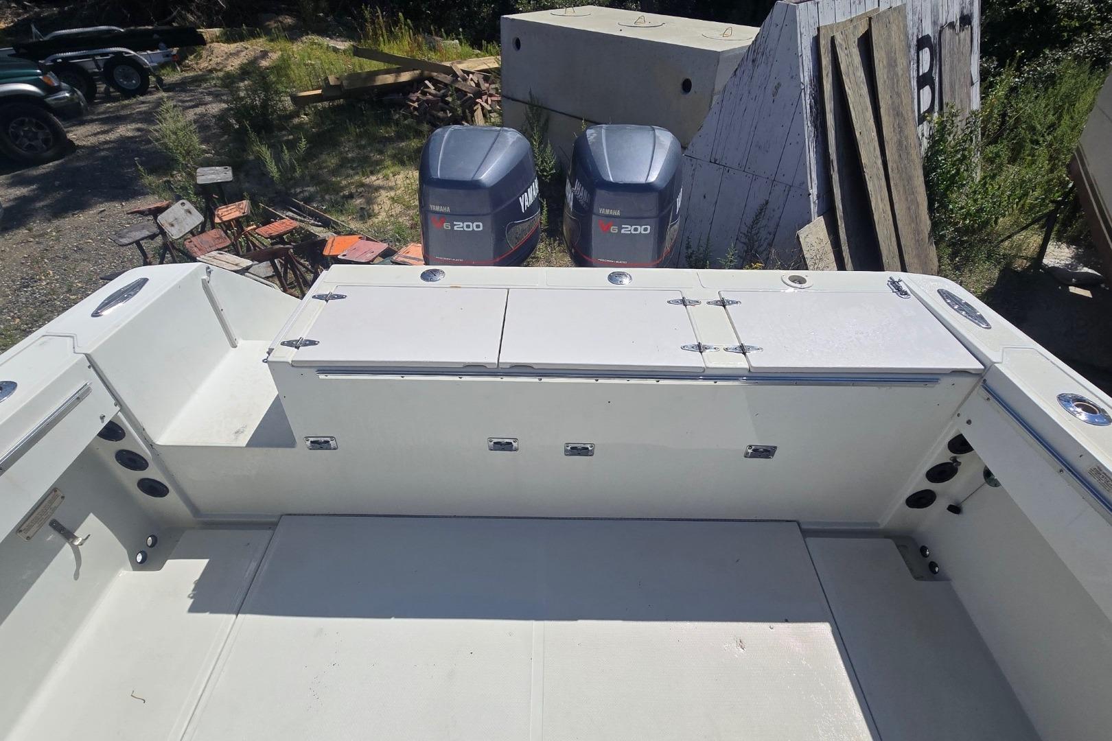 1997 Stamas 270 Tarpon boat deck with dual Yamaha 200 engines in a yard setting.