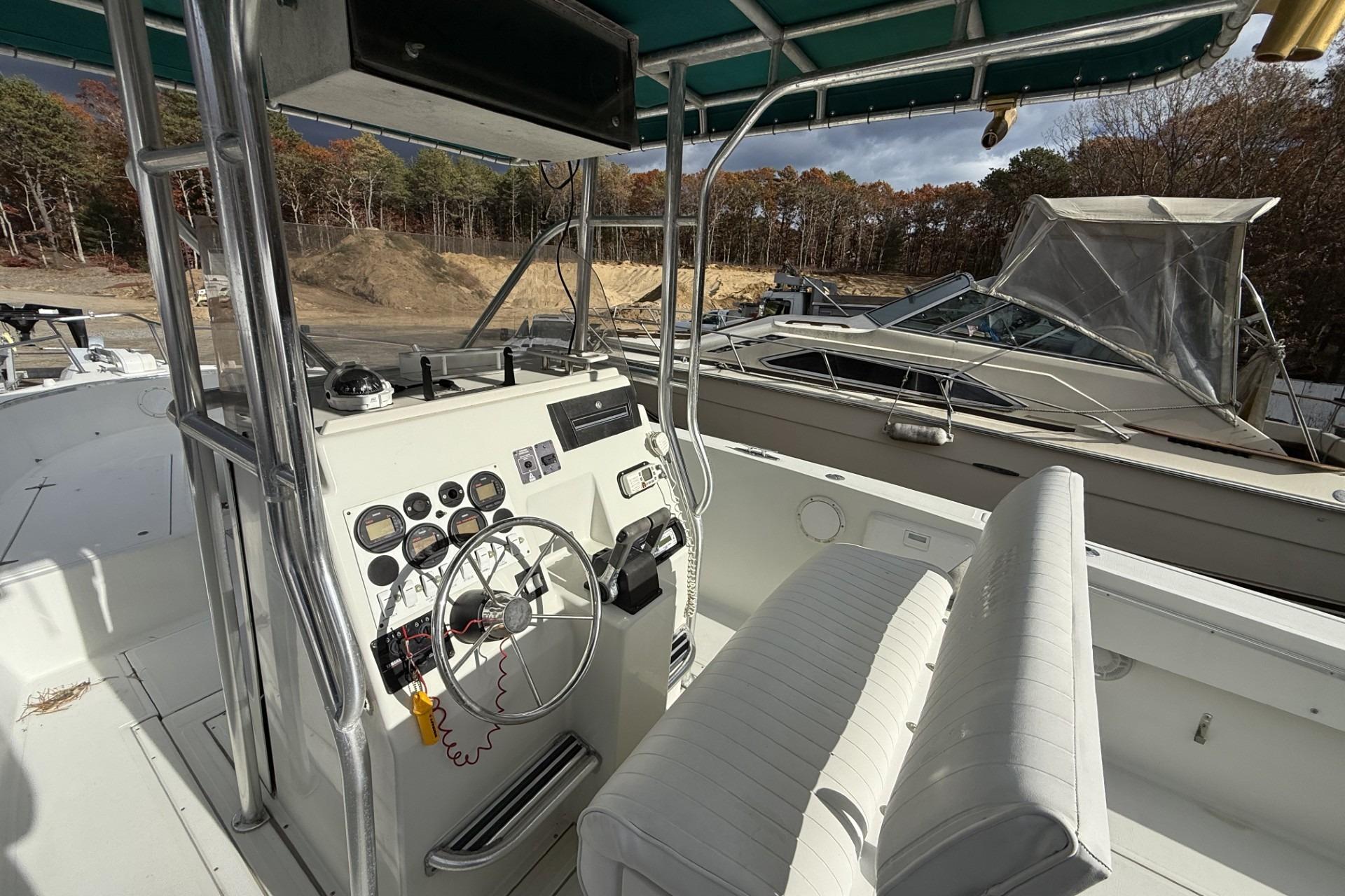1997 Stamas 270 Tarpon boat cockpit with steering wheel and control panel.