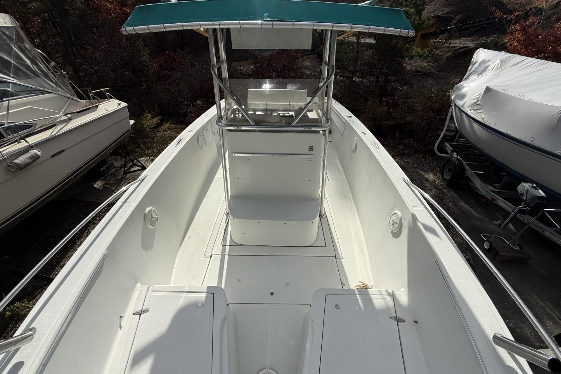 1997 Stamas 270 Tarpon boat with center console and teal canopy, docked outdoors.