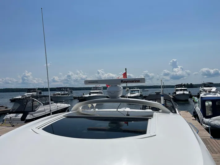  Yacht Photos Pics 2012 Sea Ray 450 Sundancer docked with other boats under a clear sky.