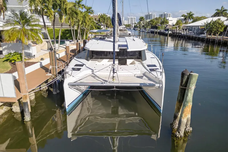  Yacht Photos Pics 2019 Leopard 45 catamaran docked in a scenic marina with palm trees.