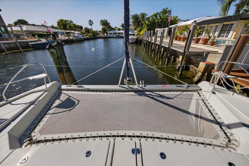  Yacht Photos Pics 2019 Leopard 45 catamaran docked in a sunny, tropical canal setting.