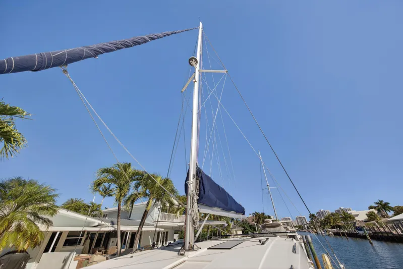  Yacht Photos Pics Sailboat docked by palm trees, Leopard 45 model, 2019, under clear blue sky.