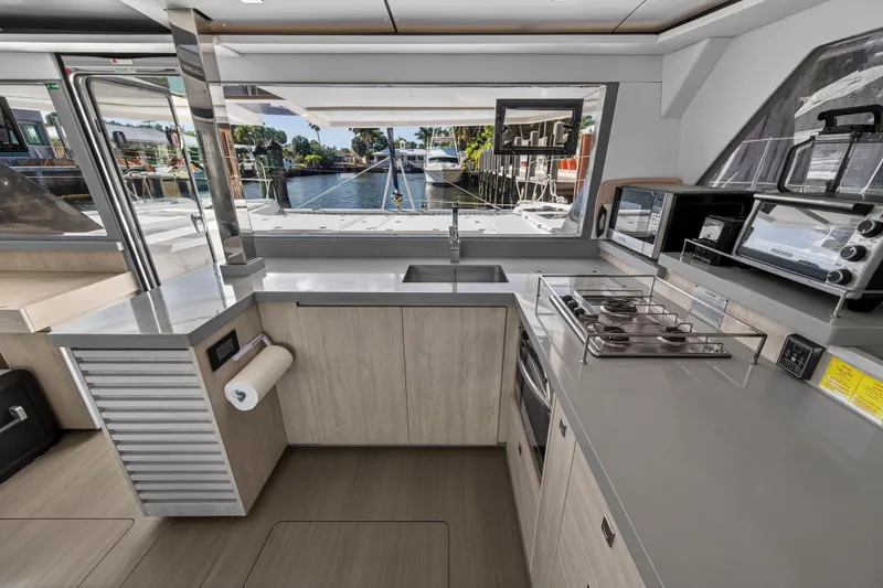  Yacht Photos Pics Modern kitchen interior on a 2019 Leopard 45 catamaran, featuring sleek countertops and appliances.