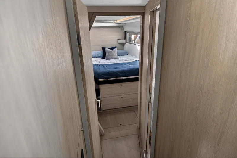  Yacht Photos Pics Interior of 2019 Leopard 45 yacht showing cozy bedroom with wooden finish.