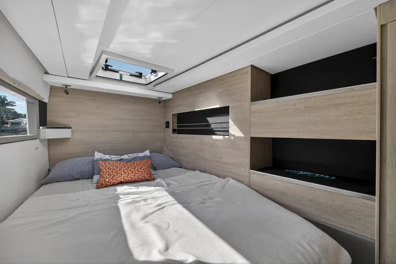  Yacht Photos Pics Modern bedroom interior in a 2019 Leopard 45 yacht, featuring skylight and wooden accents.