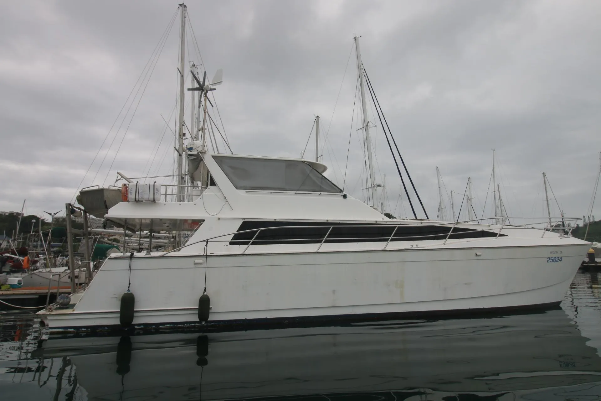 1991 Mitchell Powercat 58 yacht docked in a marina under cloudy skies.