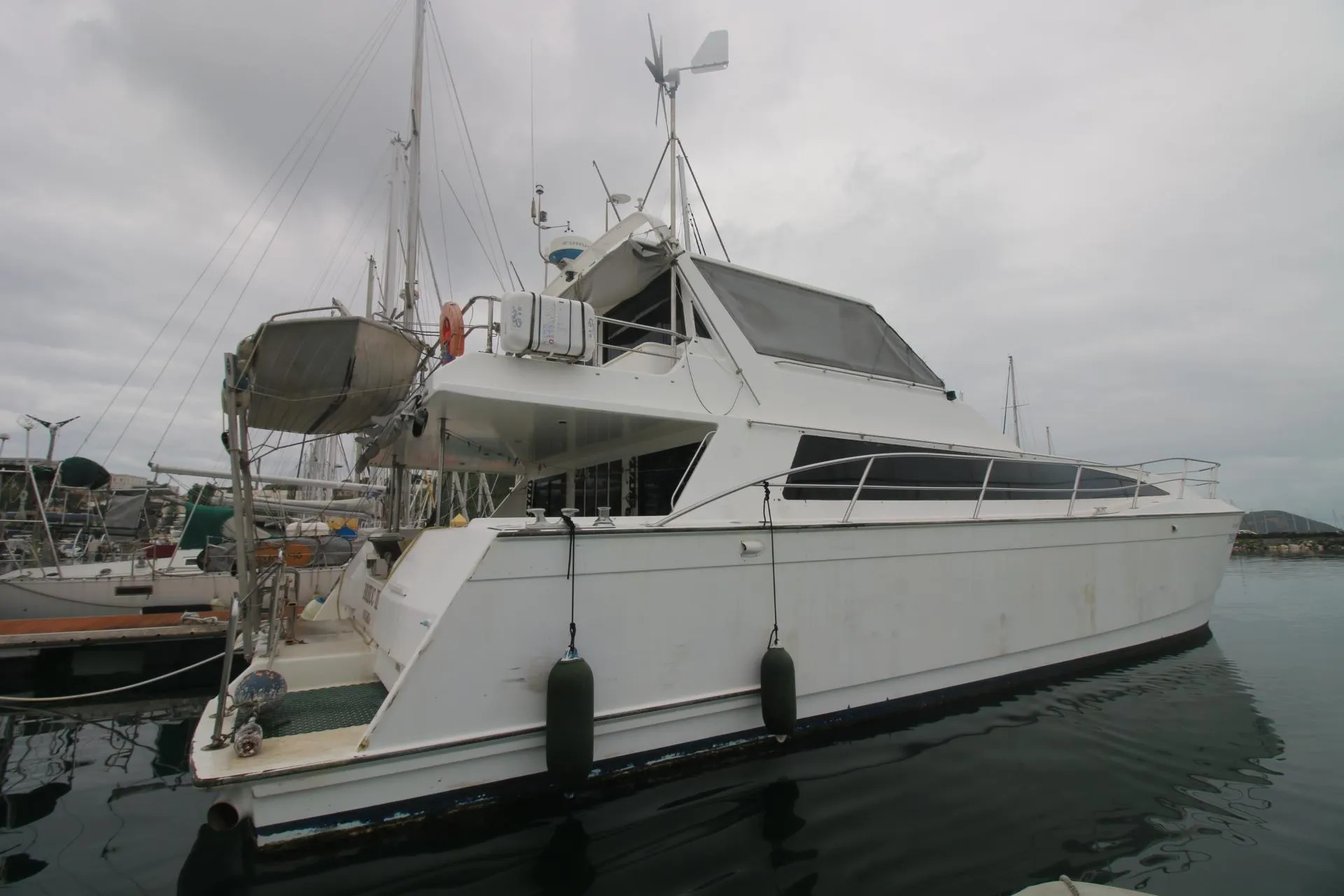 1991 Mitchell Powercat 58 yacht docked in a marina, overcast sky.