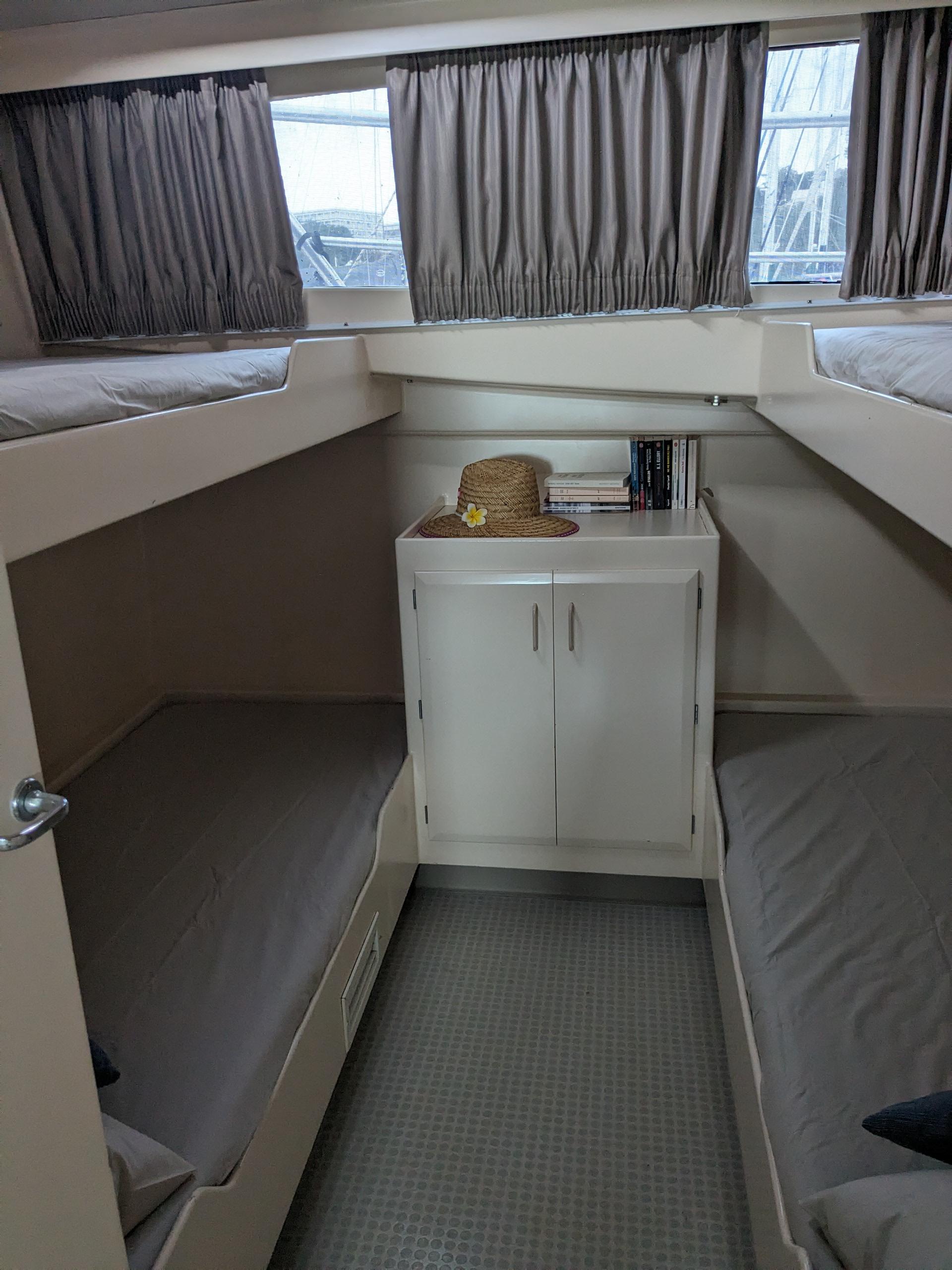 Cabin interior of 1991 Mitchell Powercat 58 with bunk beds and storage cabinet.