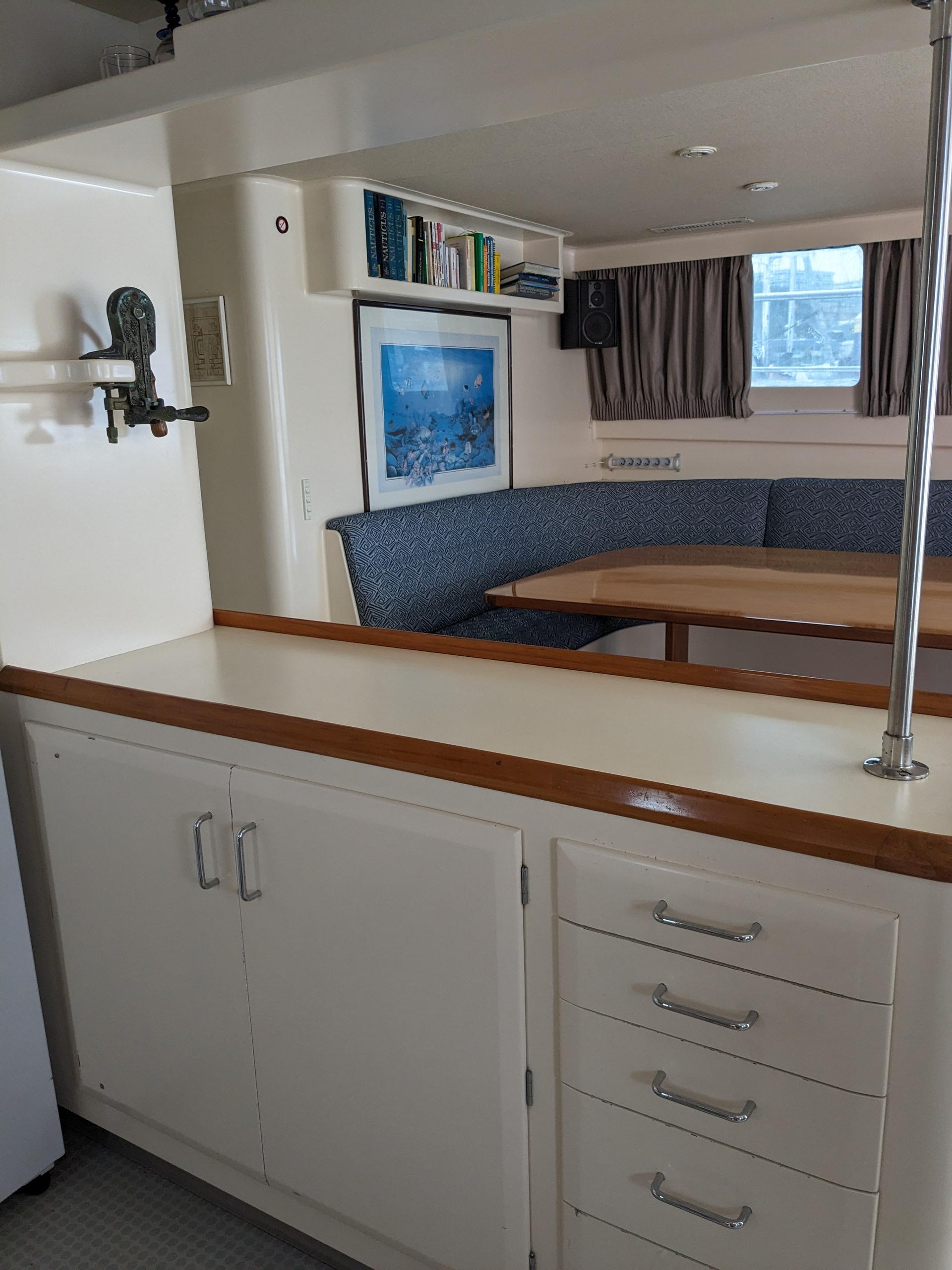 Interior of 1991 Mitchell Powercat 58 with cozy seating, wooden table, and storage cabinets.