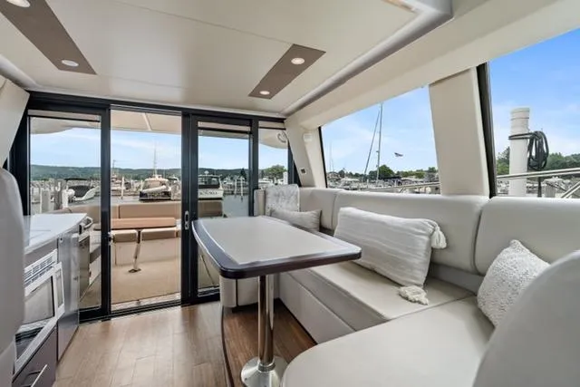 Horizen Yacht Photos Pics Luxurious interior of 2017 Regal 42 Grande Coupe yacht with elegant seating and scenic marina view.