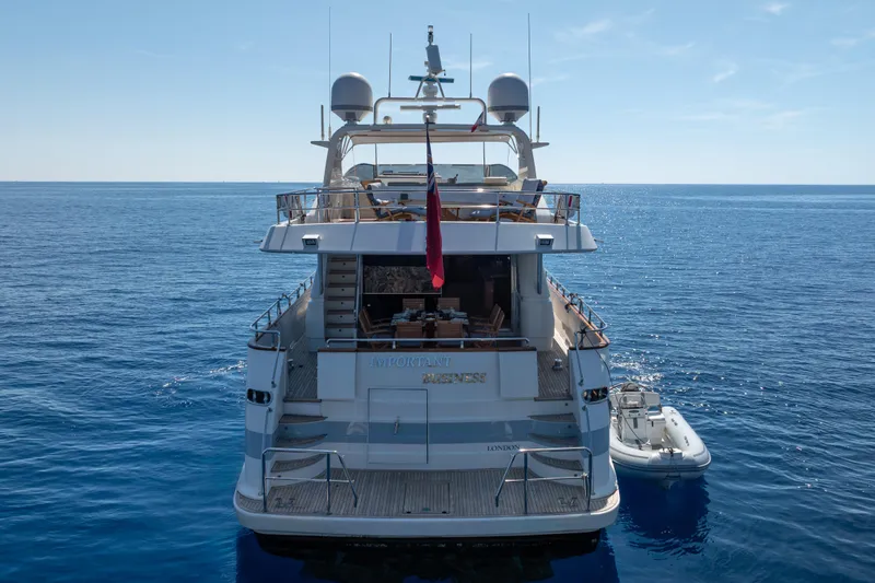  Yacht Photos Pics Luxurious 1999 Falcon Yachts 86 on serene ocean waters, rear view.