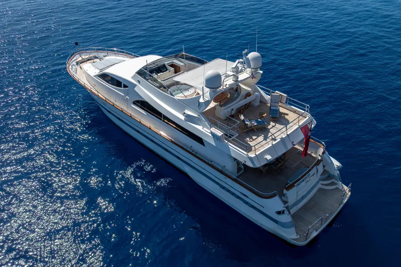  Yacht Photos Pics Aerial view of 1999 Falcon Yachts 86 luxury yacht cruising on blue ocean waters.