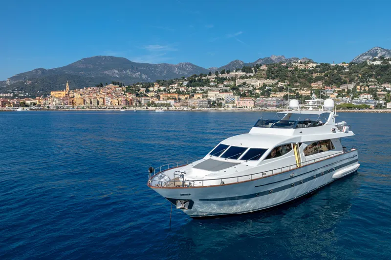  Yacht Photos Pics Luxury Falcon Yachts 86 (1999) cruising near scenic coastal town and mountains.