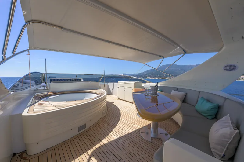  Yacht Photos Pics Luxurious deck of 1999 Falcon Yachts 86 with seating and jacuzzi, overlooking the sea.