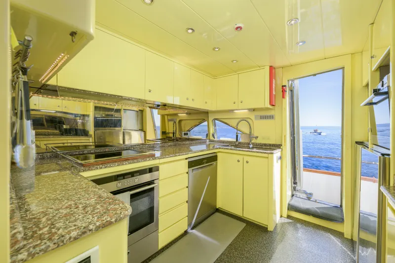  Yacht Photos Pics Luxurious yellow kitchen on 1999 Falcon Yachts 86, featuring modern appliances and ocean view.