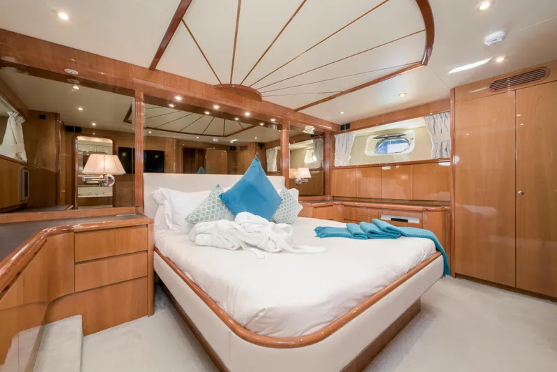  Yacht Photos Pics Luxurious bedroom interior of 1999 Falcon Yachts 86, featuring elegant wood finishes and plush bedding.