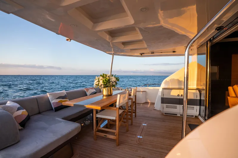 Omnia Yacht Photos Pics Luxurious 2018 Pearl 80 yacht deck with elegant seating and ocean view at sunset.