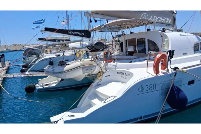 Sunny Days Yacht Photos Pics Lagoon 380 S2 catamaran docked at marina, 2013 model, with inflatable dinghy.