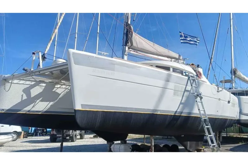 Sunny Days Yacht Photos Pics 2013 Lagoon 380 S2 catamaran on land with Greek flag, ladder access.