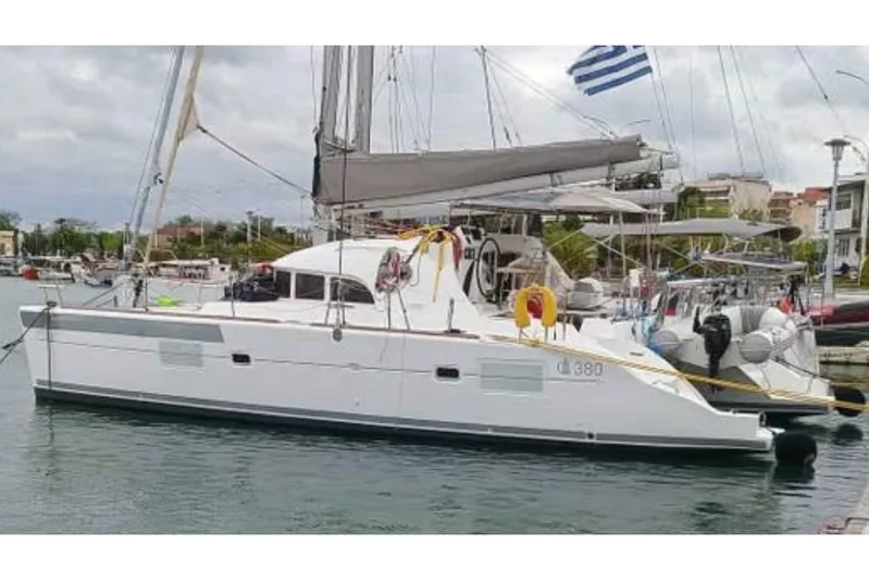 Sunny Days Yacht Photos Pics 2013 Lagoon 380 S2 catamaran docked in a marina with Greek flag.