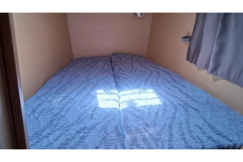 Sunny Days Yacht Photos Pics Cozy cabin interior of 2013 Lagoon 380 S2 catamaran with twin beds and soft lighting.