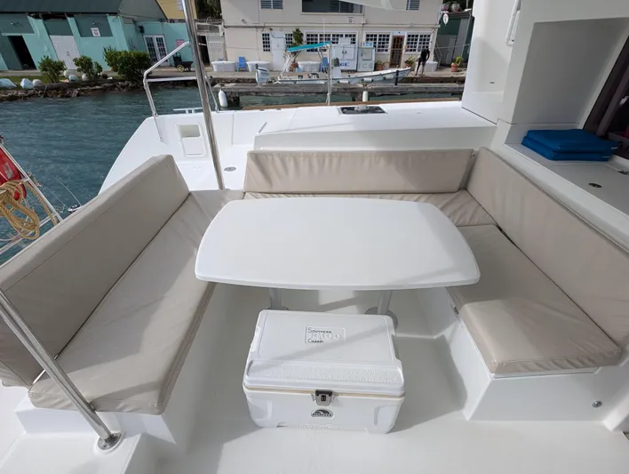 Southern Charm Yacht Photos Pics Outdoor seating area on 2015 Lagoon 450 F catamaran with table and cushions.