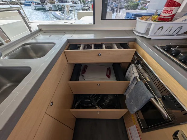 Southern Charm Yacht Photos Pics Interior view of 2015 Lagoon 450 F yacht kitchen with open drawers and appliances.