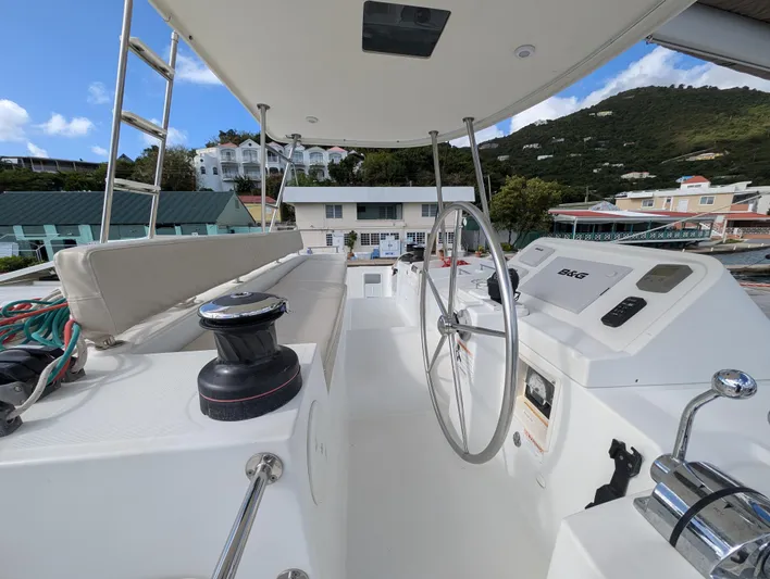 Southern Charm Yacht Photos Pics Helm of 2015 Lagoon 450 F catamaran with scenic marina backdrop.