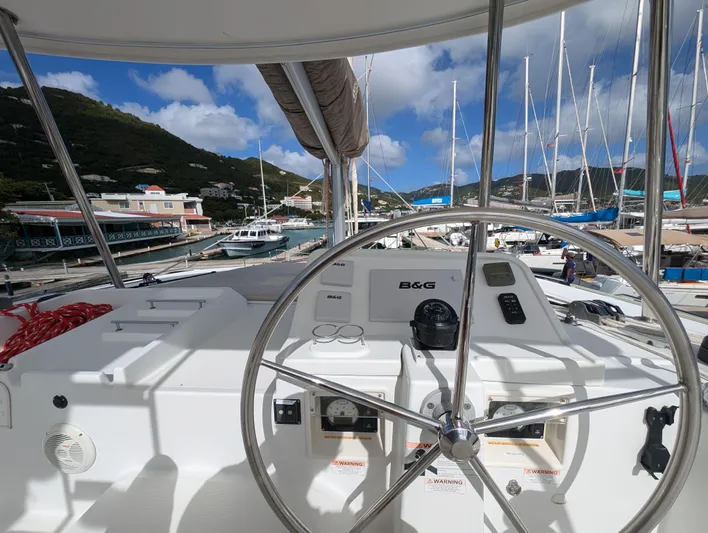 Southern Charm Yacht Photos Pics Helm of 2015 Lagoon 450 F catamaran docked at marina with scenic background.