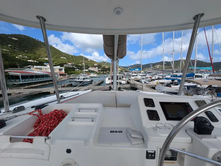 Southern Charm Yacht Photos Pics Cockpit view of 2015 Lagoon 450 F catamaran docked at a marina with scenic hills.