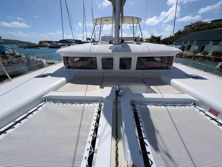 Southern Charm Yacht Photos Pics 2015 Lagoon 450 F catamaran with spacious deck and netting, docked in a sunny marina.