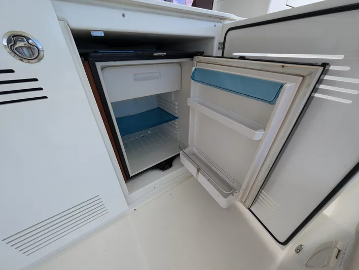 Southern Charm Yacht Photos Pics Open refrigerator on a 2015 Lagoon 450 F yacht, showcasing interior storage space.