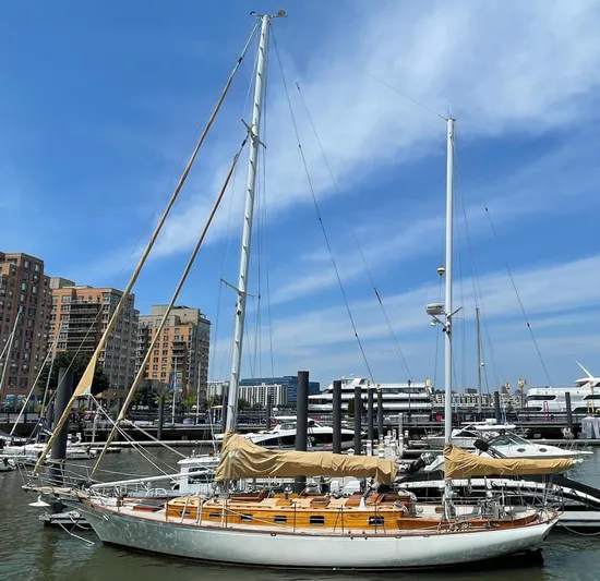 Sappho Yacht Photos Pics 1983 Cherubini 44 Ketch sailboat docked in a marina with cityscape background.
