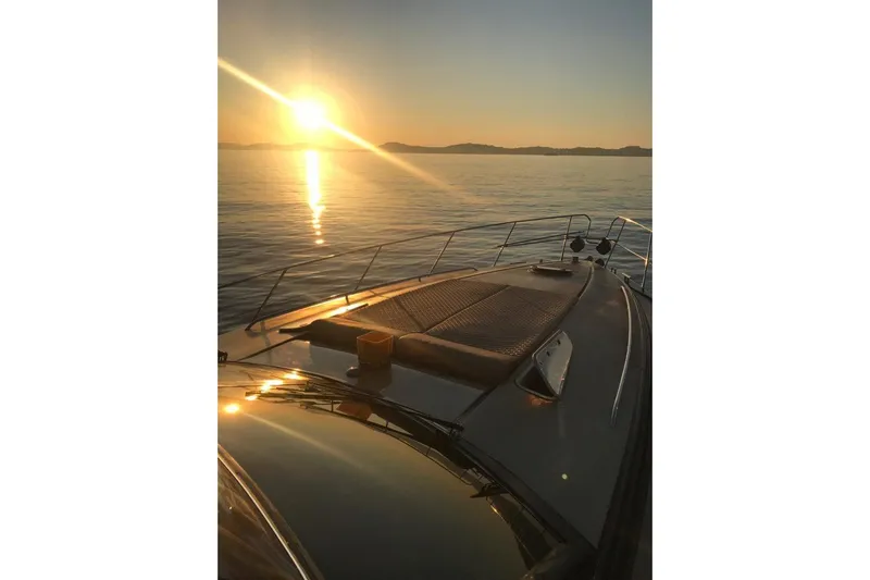  Yacht Photos Pics Sunset view from a 1996 Princess V52 yacht on calm waters.