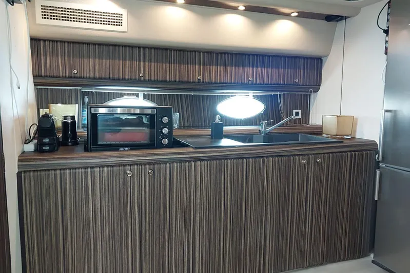  Yacht Photos Pics Modern kitchen interior on a 1996 Princess V52 yacht, featuring wood cabinetry and appliances.