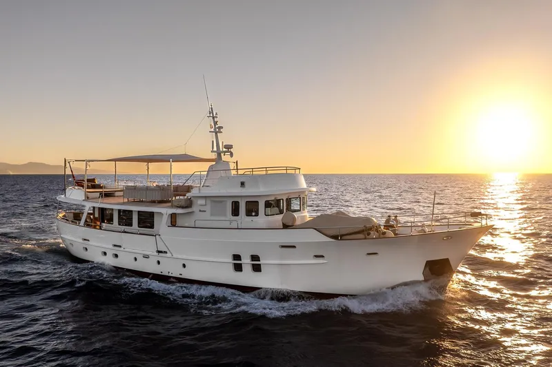 Sultana Yacht Photos Pics Vintage 1969 Feadship 25.8m yacht cruising at sunset on open sea.