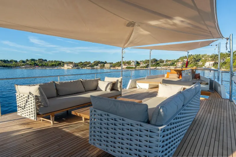 Sultana Yacht Photos Pics Luxurious 1969 Feadship 25.8m yacht deck with elegant seating and scenic waterfront view.